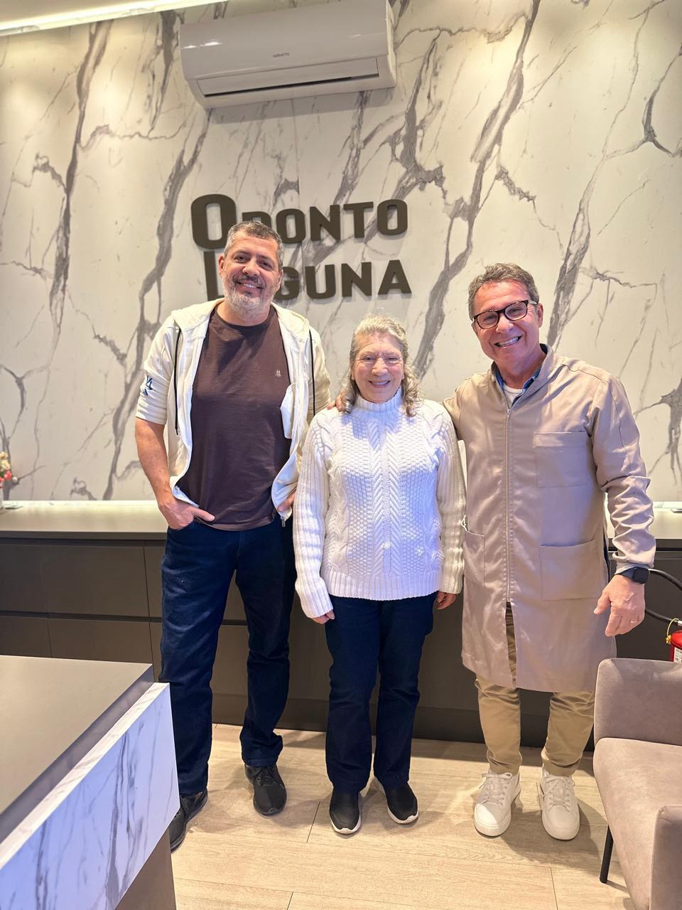 Dr. Luiz com pacientes na recepção da Odonto Laguna